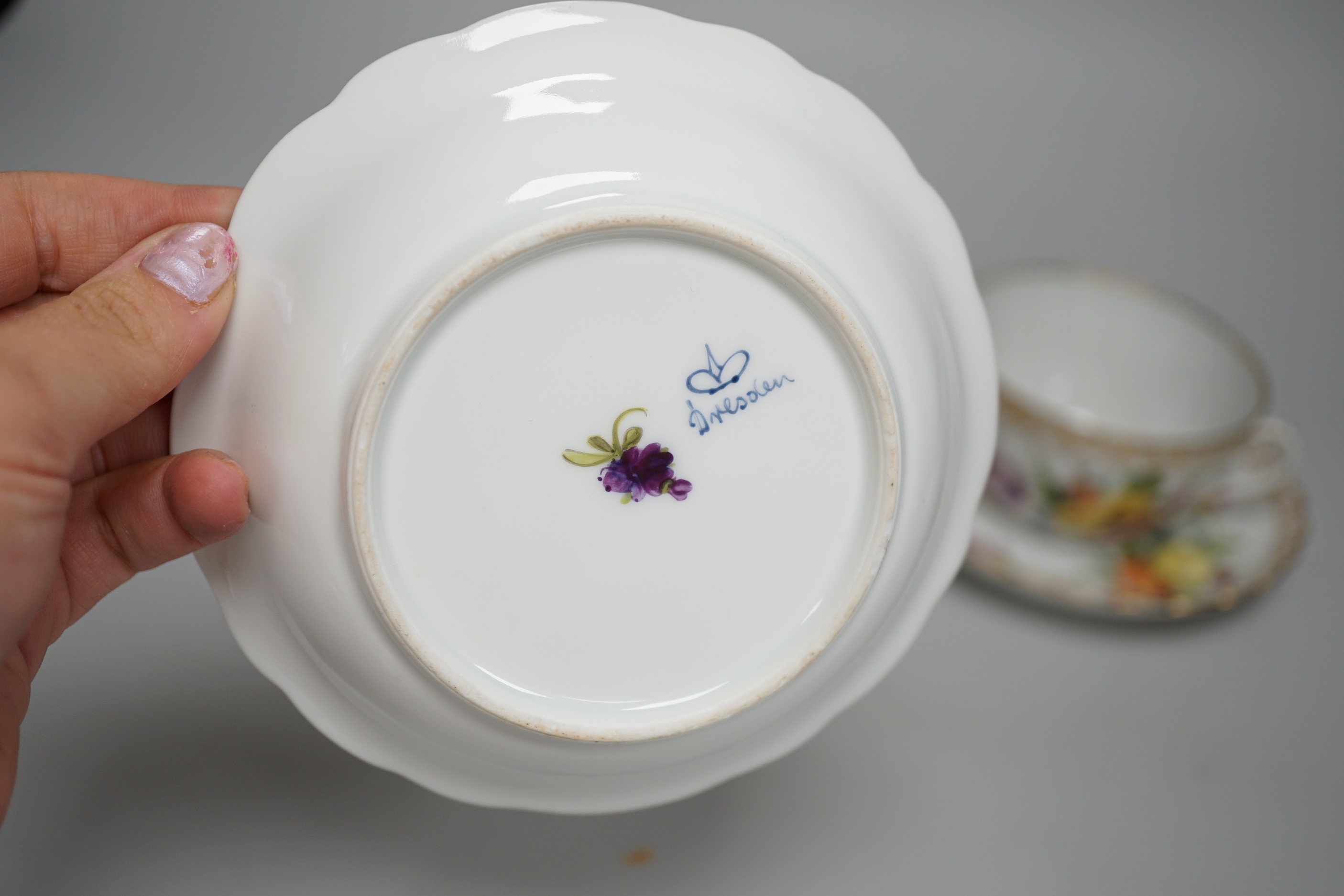 A Meissen style porcelain teacup and saucer together with a Dresden saucer and teacup and saucer